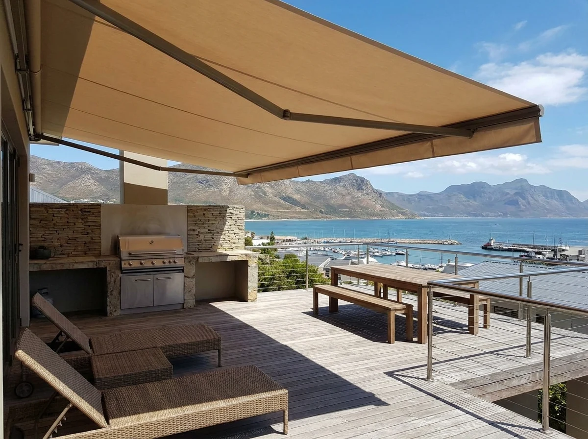 Retractable folding-arm awning extended for shade over a braai deck above the Gordon's Bay harbour